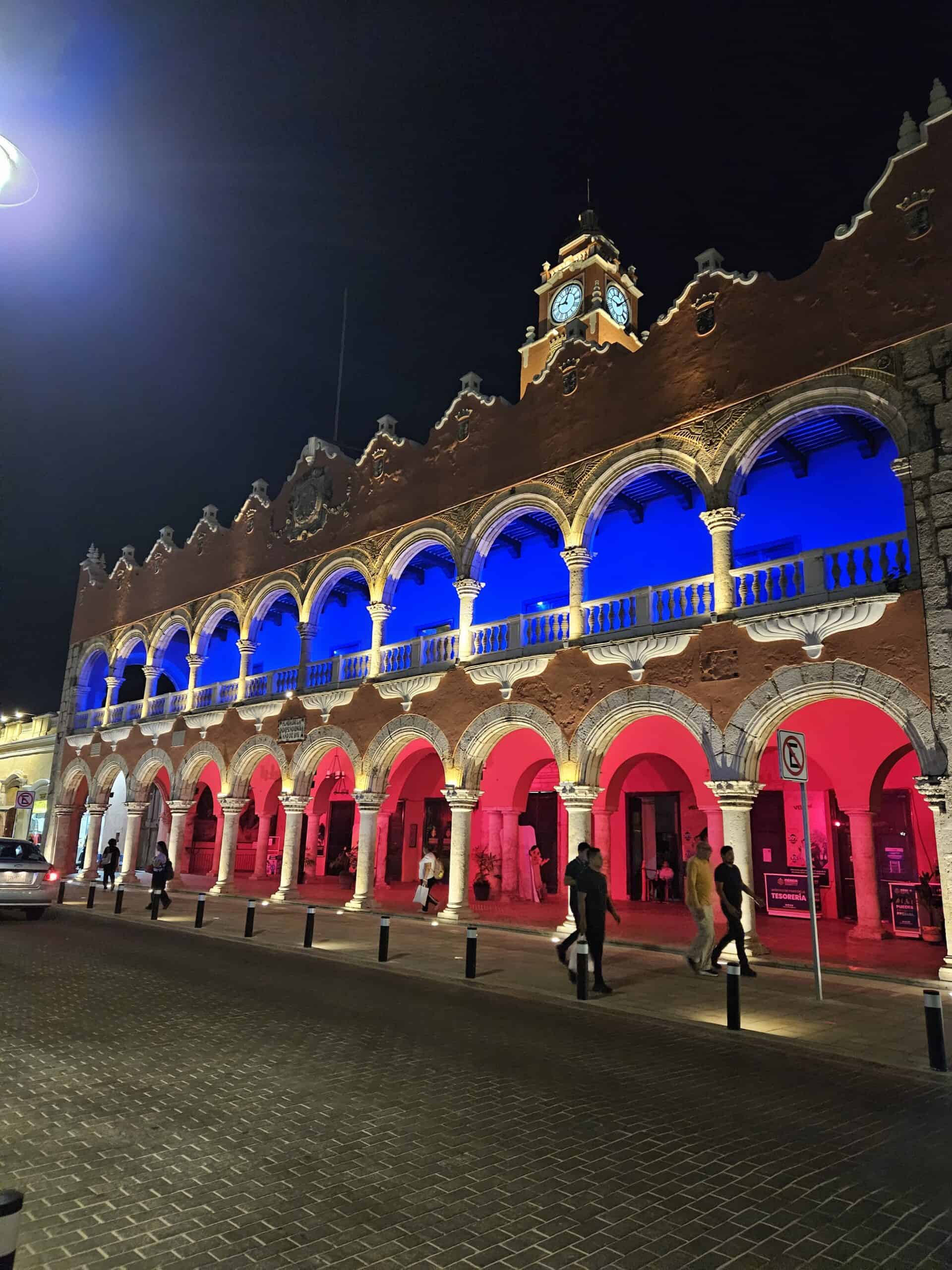 Night scene in the main plaza of Merida Mexico lit up in blue and red