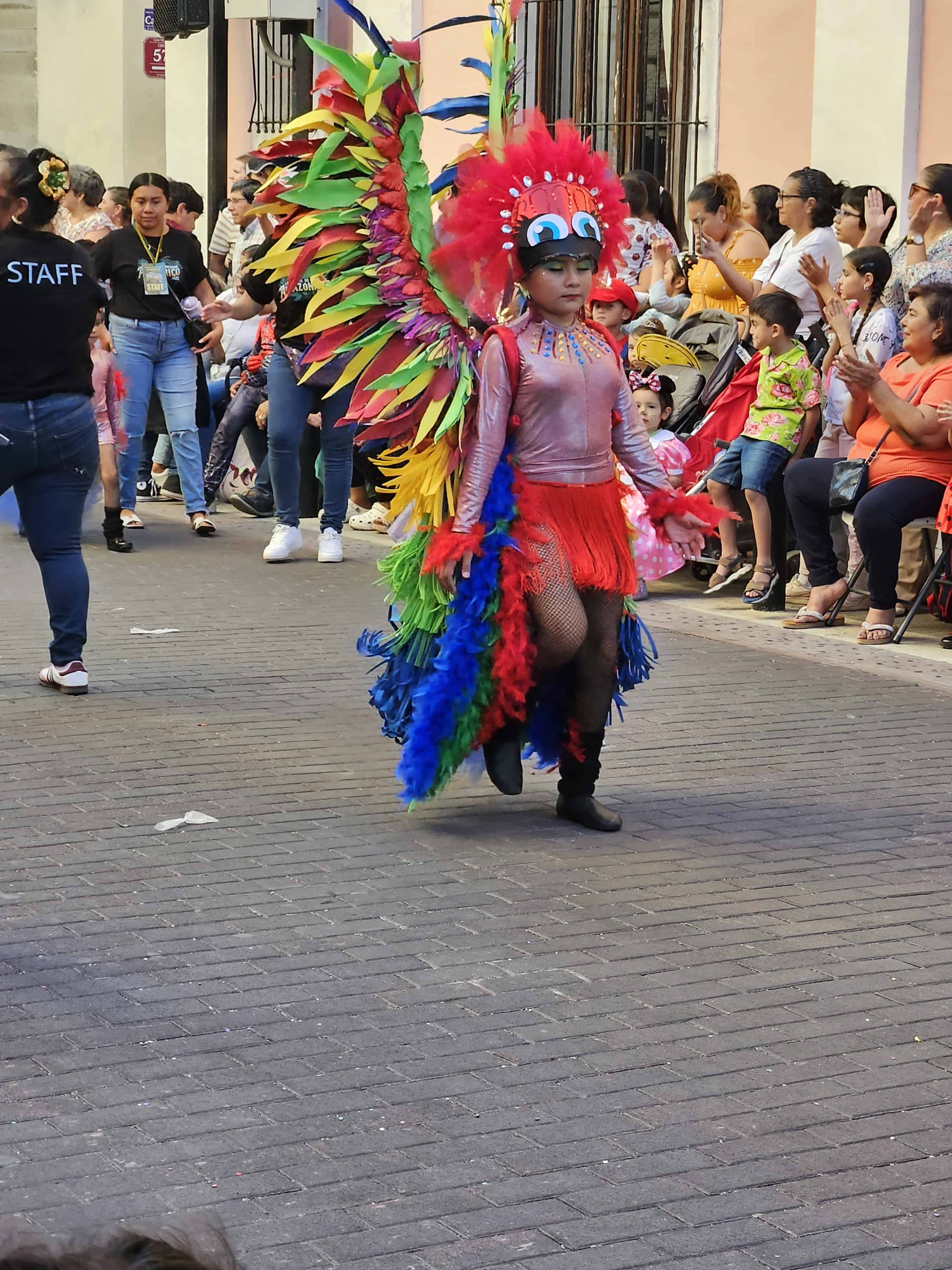 Scene from a festival of a young lady in a red head dress in Merida Mexico
