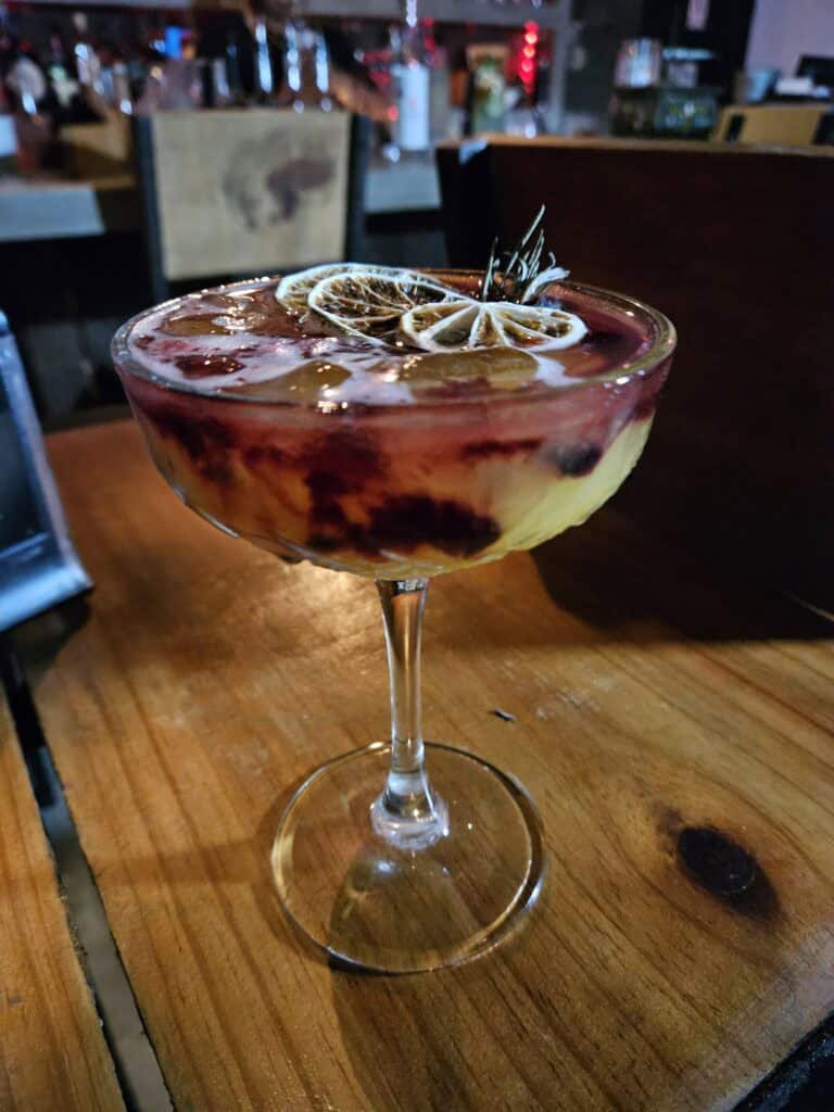 Photo of cocktail, pink and yellow at a Mezcaleria in Merida Mexico