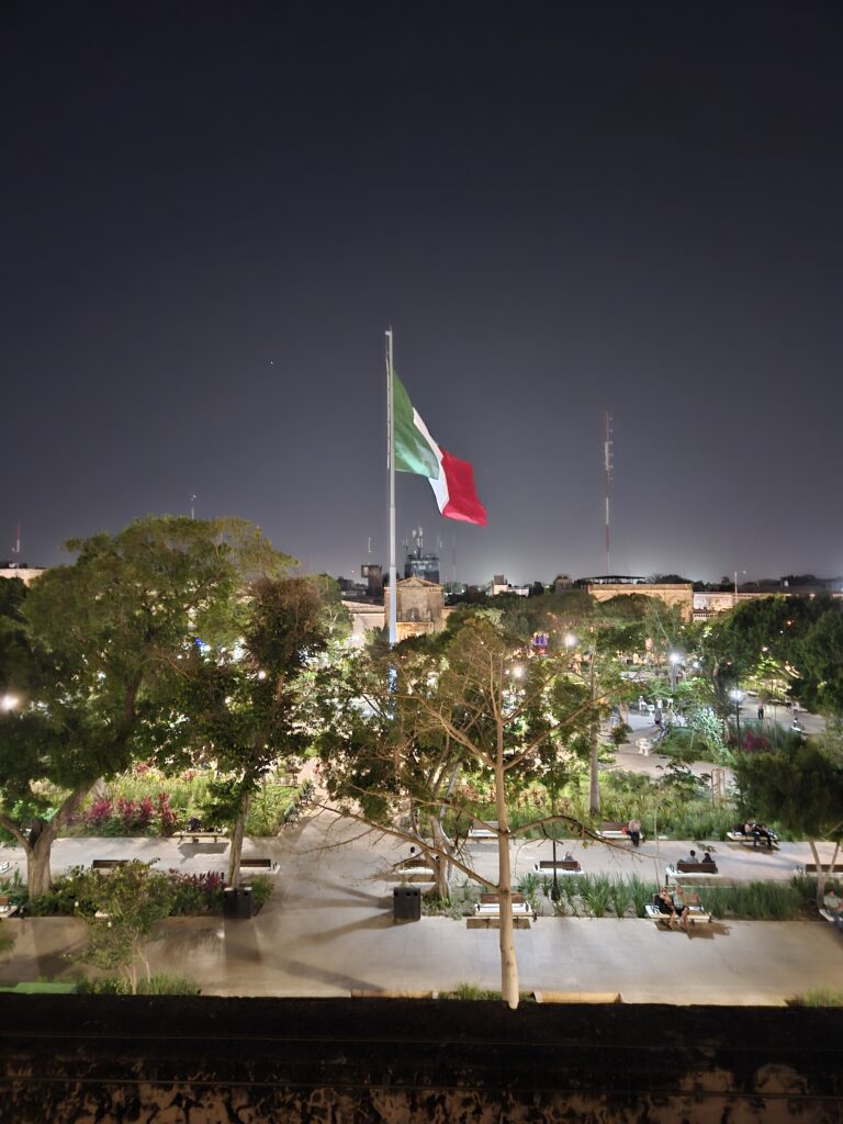 Night view of the Mexican Flag flying over the grand plaza in Merida, Mexico