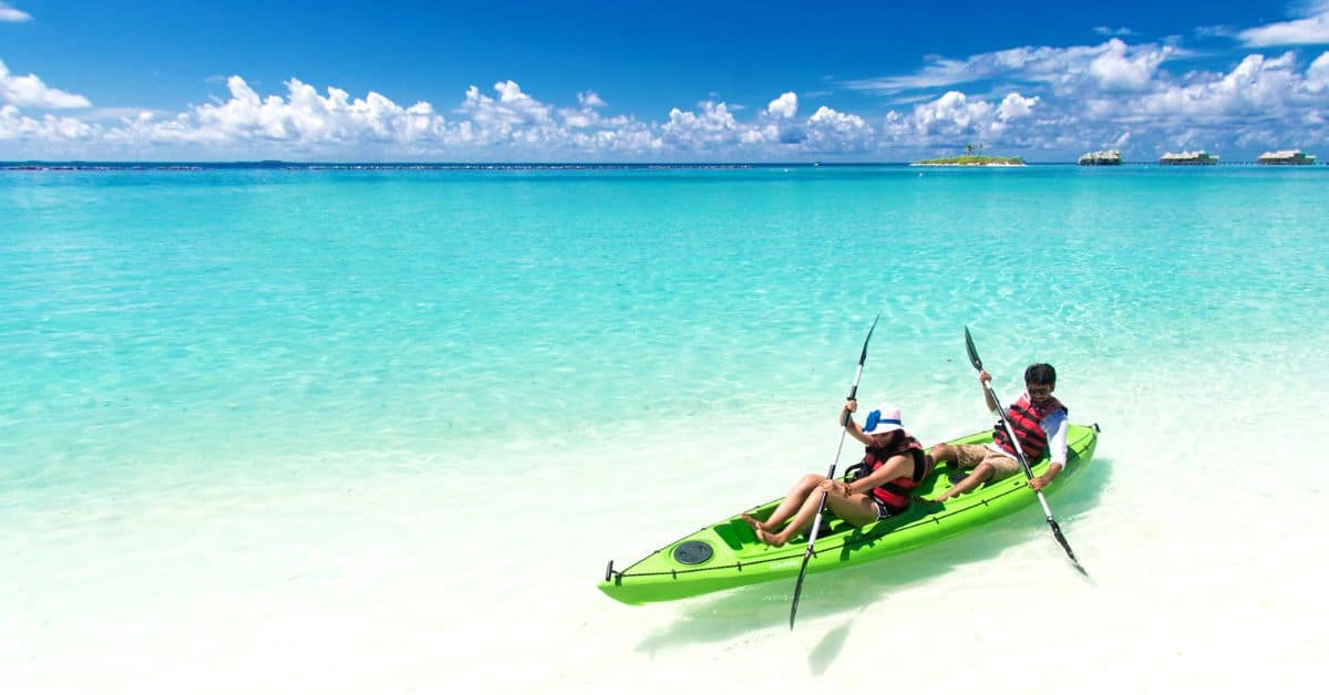 Two people in a green kayak on the beach in Sisal Mexico