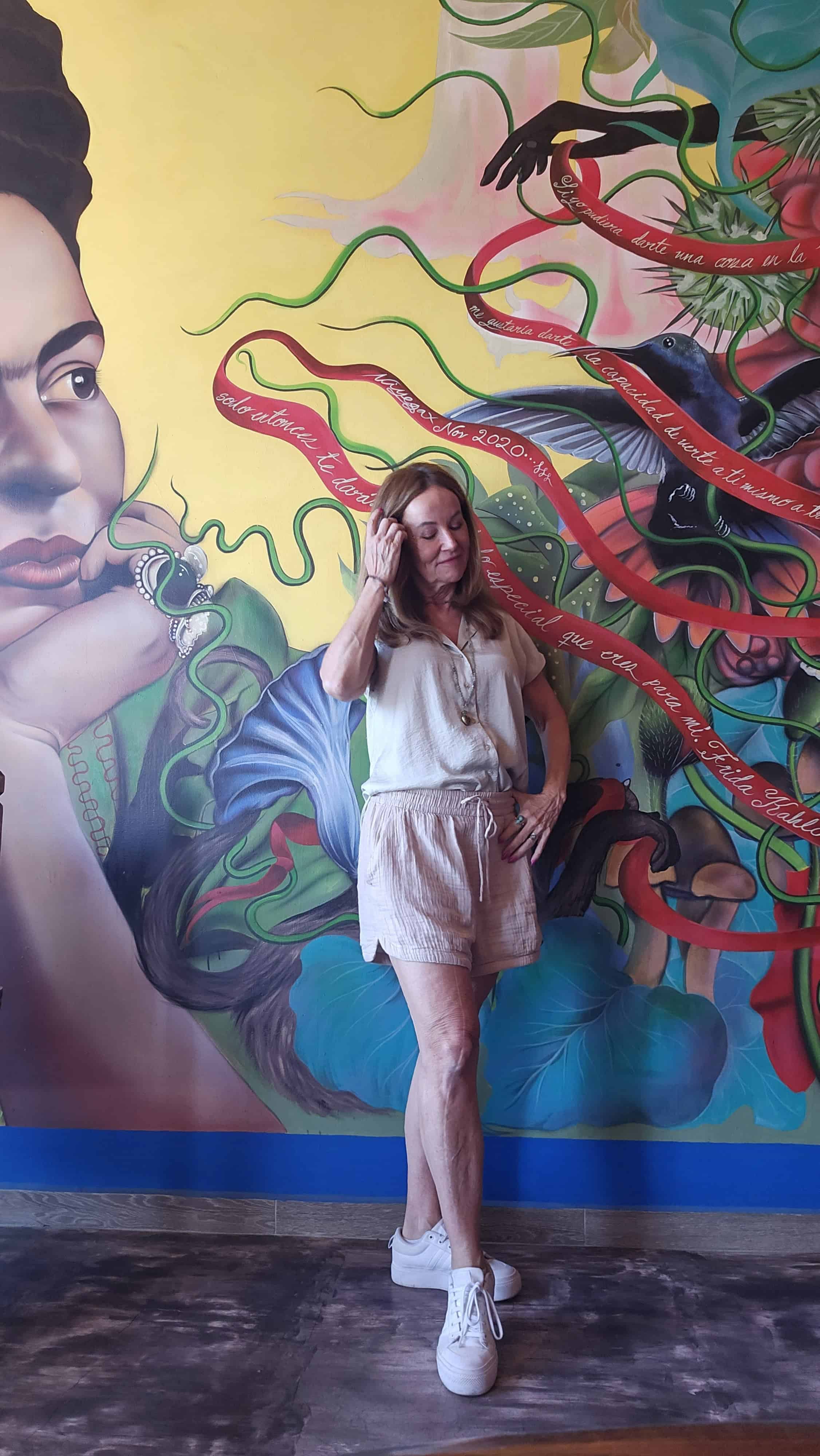 Me, Susanne Wilson, standing in front of the wall mural in Rooms by Diaza in Oaxaca, Mexico