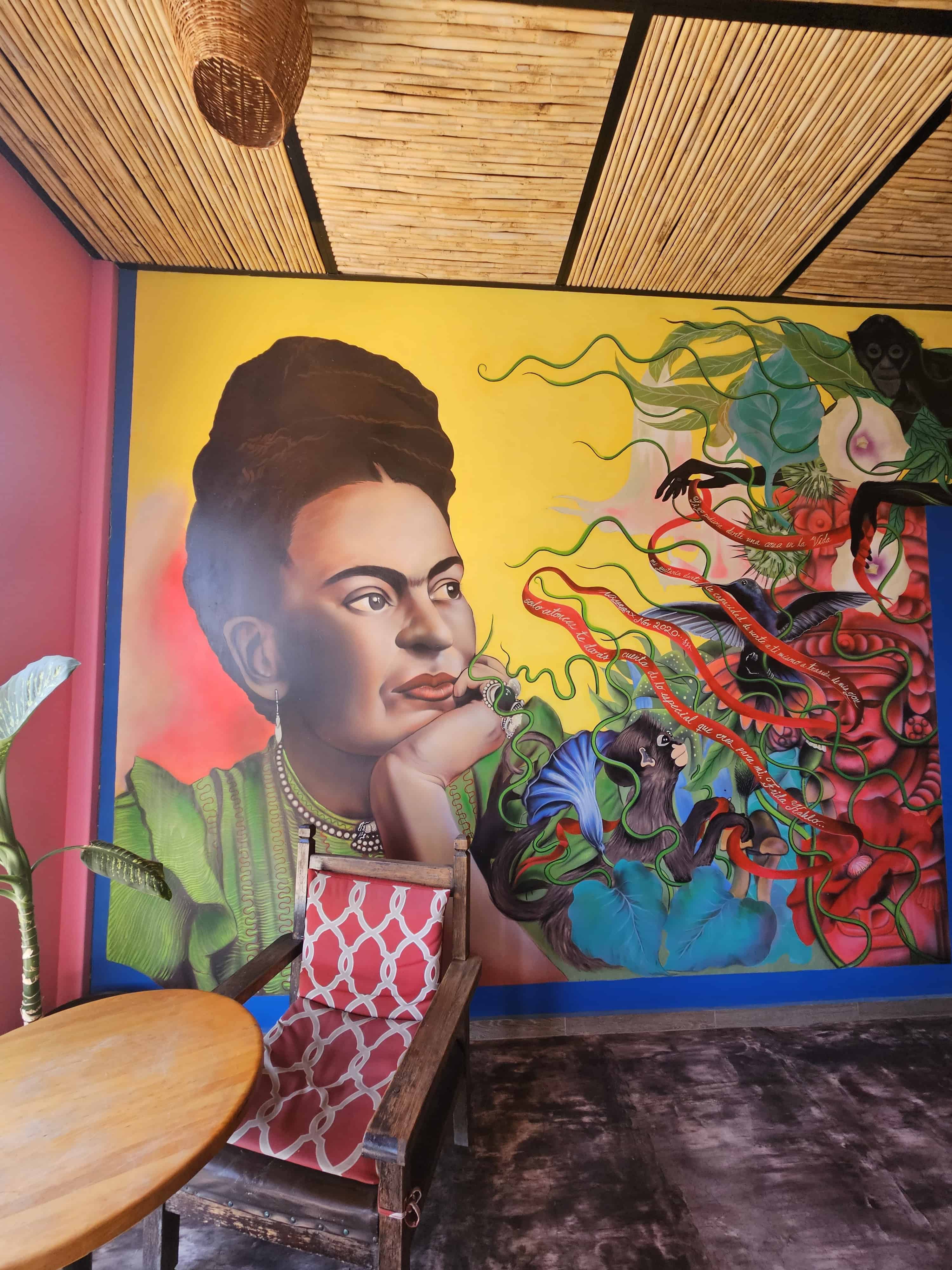 Wall mural, a woman facing the color swirls in the dining room area of Rooms by Diaza in Oaxaca, Mexico