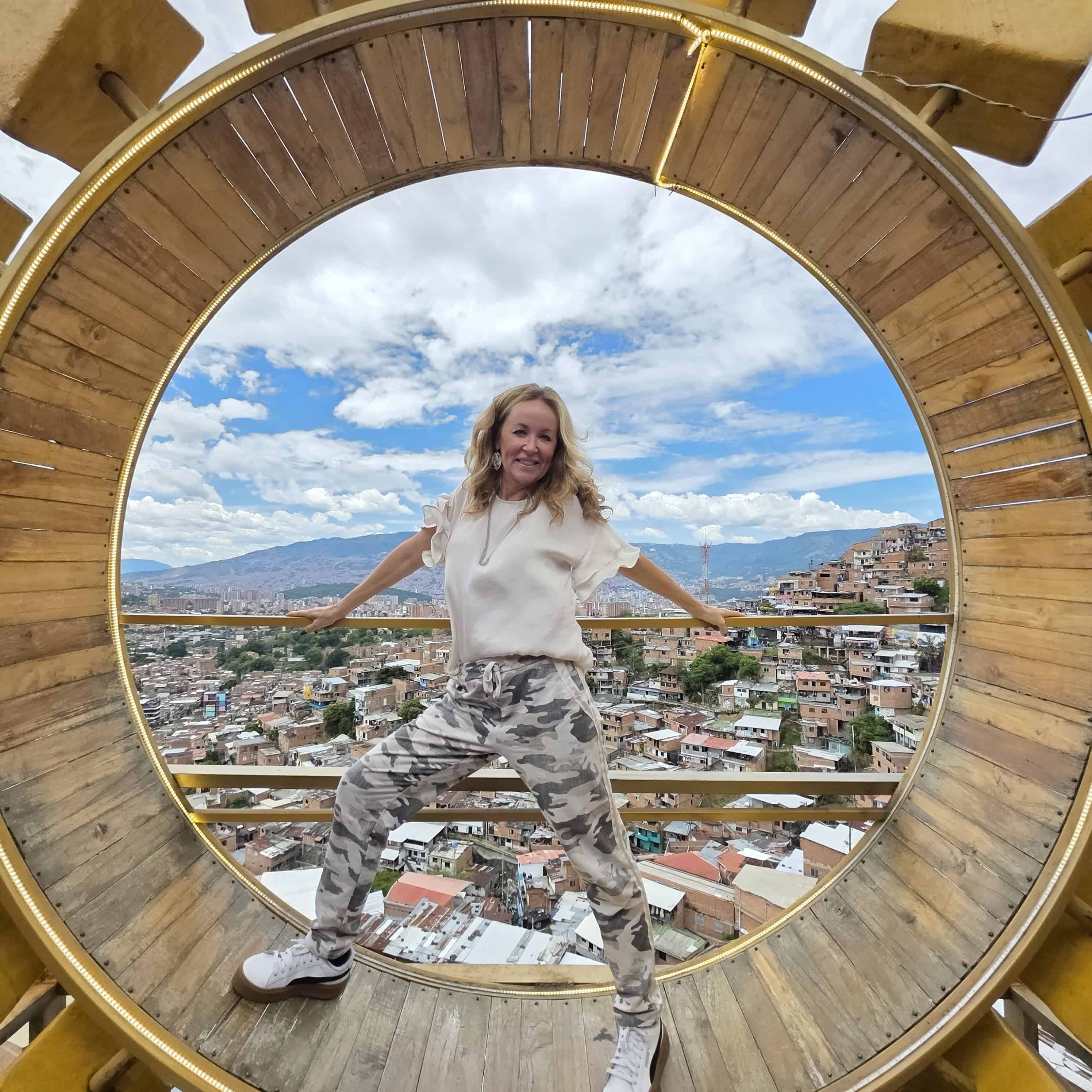 Me inside of a huge Circle posing over a view of Medellin Colombia during a tour of Comuna 13