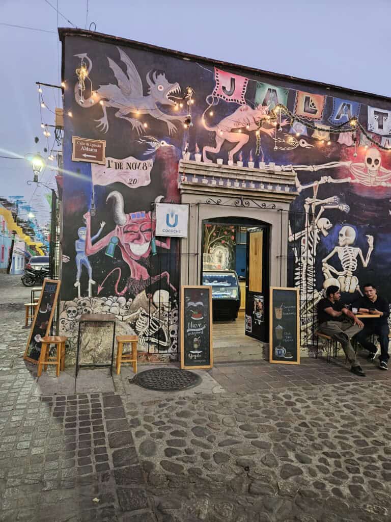 Mural os a local cafe painted with fantasical creatures like dragons, skeletons and beasts in Oaxaca, Mexico