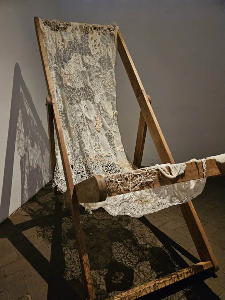 A chair with a woven, white lace material located in the textile museum in Oaxaca Mexico