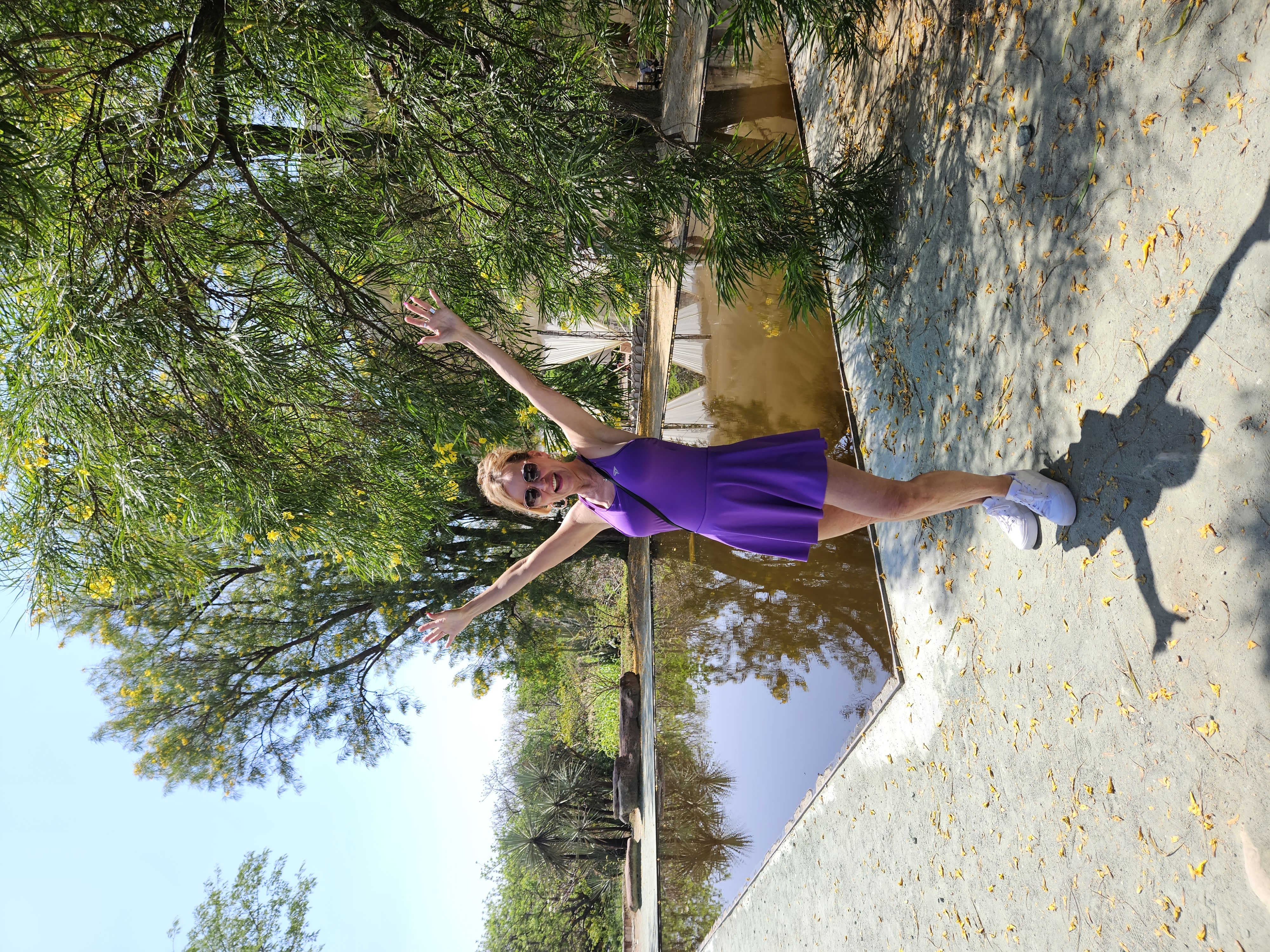 Me in a purple dress standing in front of the lake in the botanical garden in Oaxaca Mexico