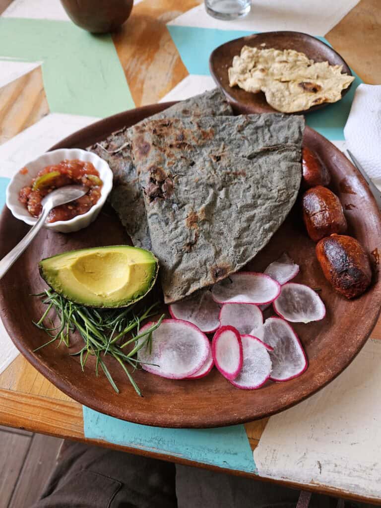 Plate of tlayuda withe a slice of avocado