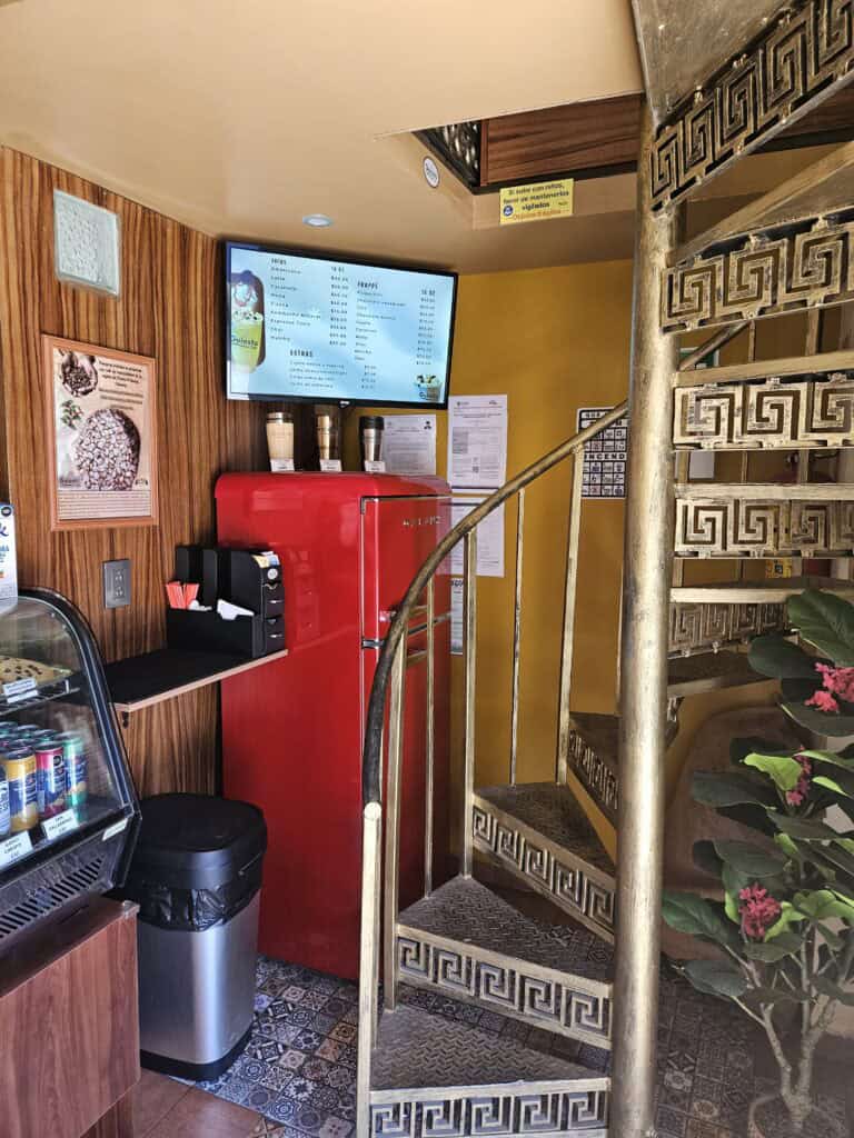 Interior of Guiosto cafe with spiral staircase, and red fridge