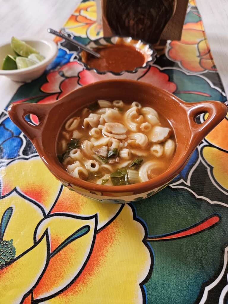 Bowl of soup with pasta in a terra cotta bowl at Restaurant Arugula in Oaxaca