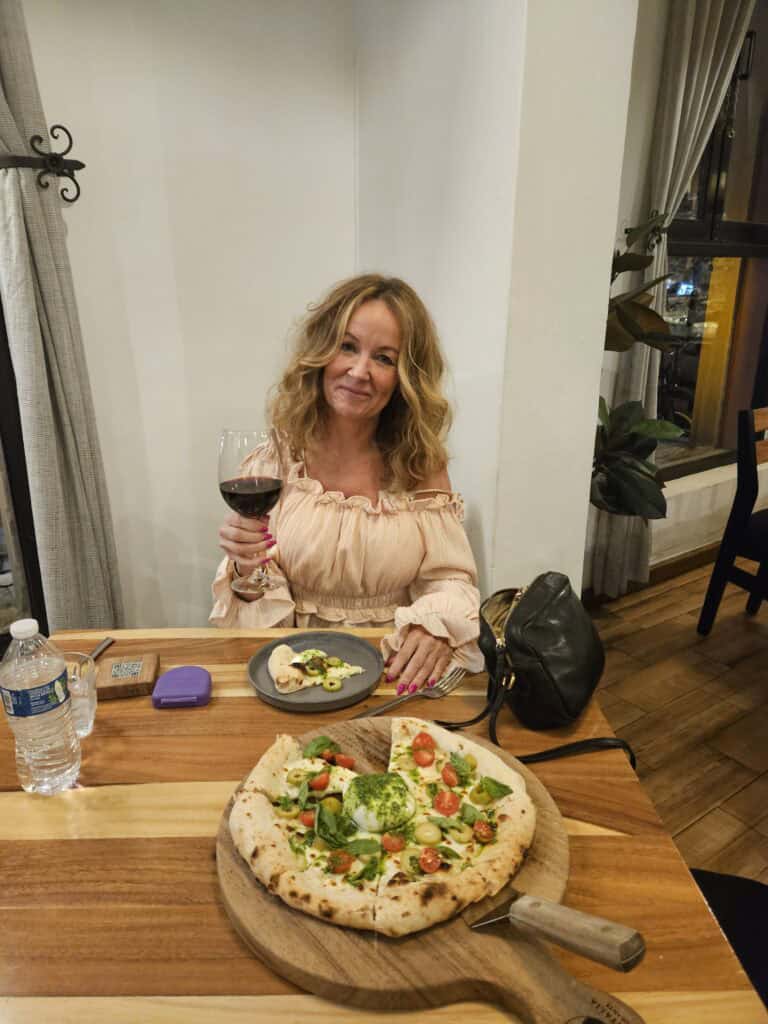 Me in Arte Italia restaurant sitting at a table with a pizza and glass of red wine