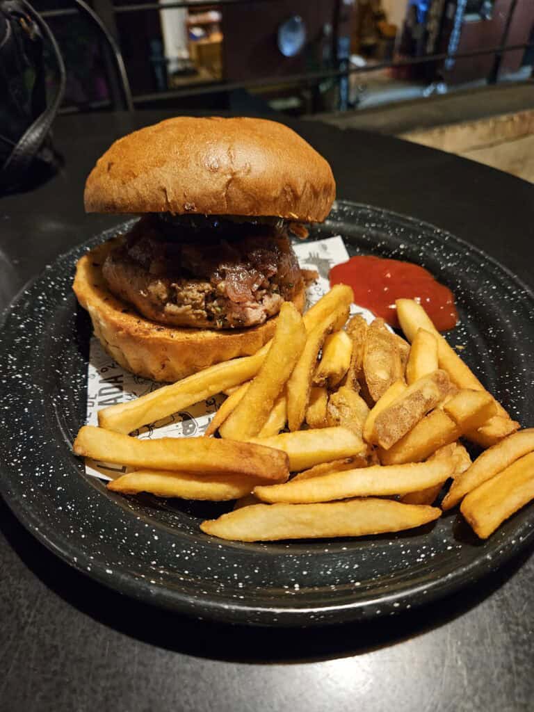 Burger and fries on a black plate at Coyote Restaurant in Oaxaca Mexico