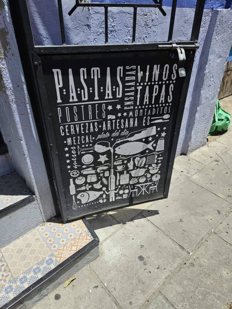 Outdoor signage for Tastavins Wine bar using a word map of all of the things on their menu along with graphics for the items.