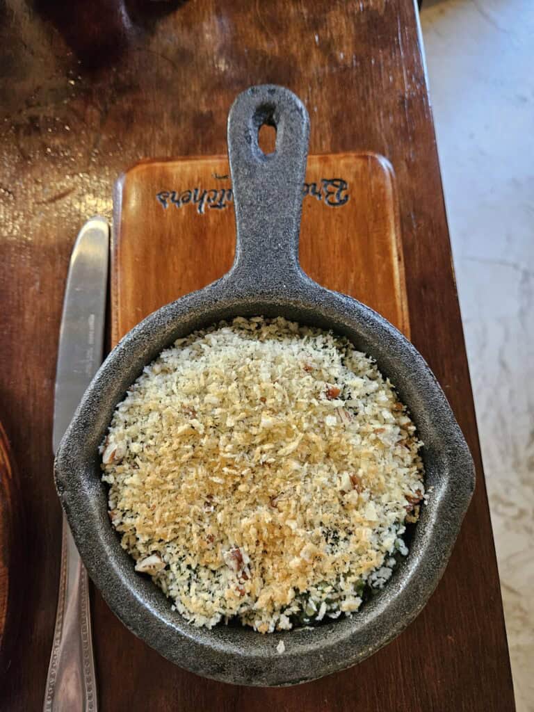 Popeye dish which is spinach with a breadcrumb crust in an iron skillet