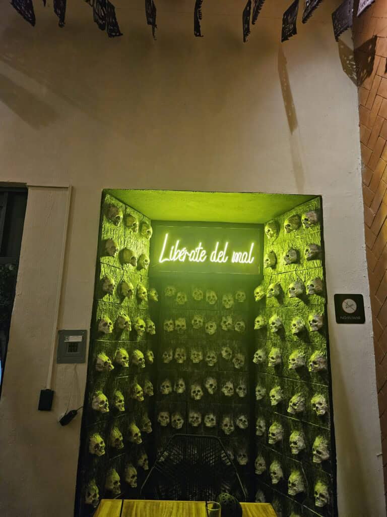 Green illuminated alcove with skulls which is the symbol at the mezcalaria in Oaxaca Mexico
