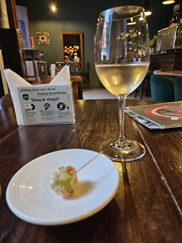 A glass of white wine and a tapa at Vino & Vinyl in Oaxaca Mexico