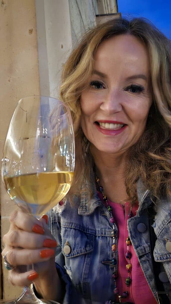 Me sitting on the balcony at Nois Restaurant with a glass of white wine