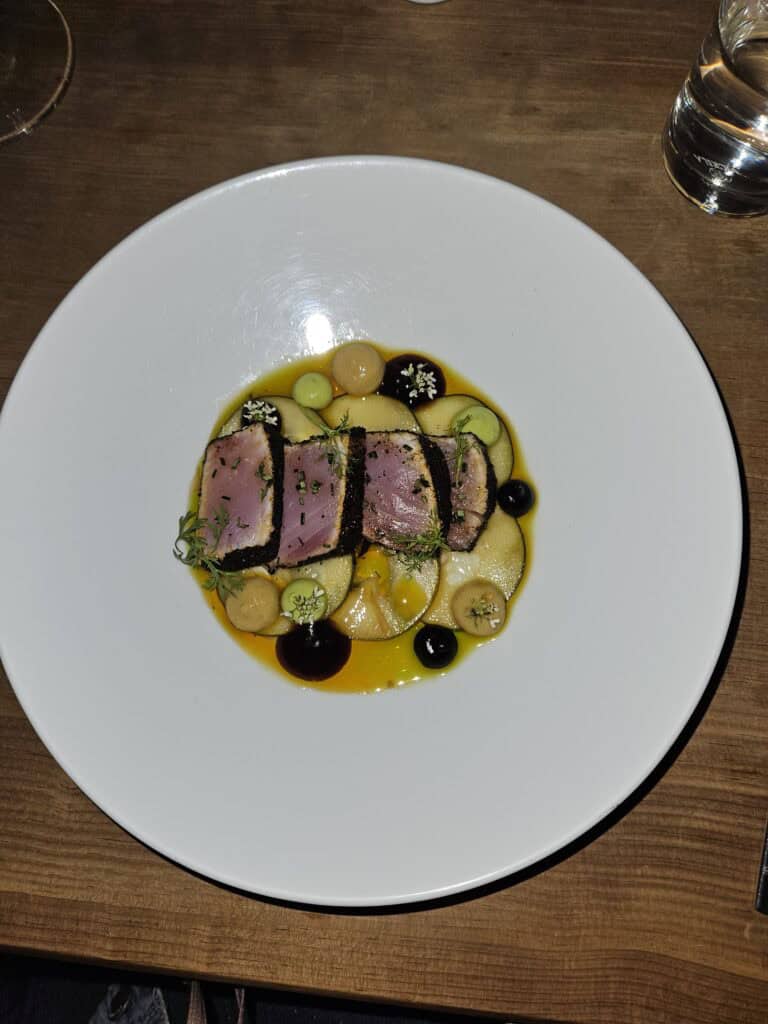 White plate with meat dish at Nois Restaurant in Oaxaca Mexico