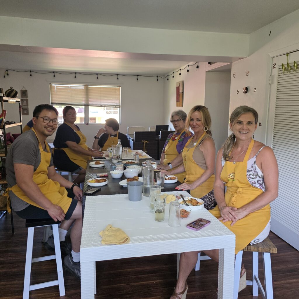People sitting around a table wearing yellow aprons during a cooking class in Panama City Panama