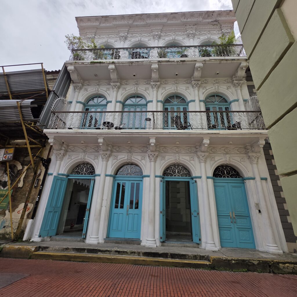 Three story white building with turquois doors and windows in Casco Viejo Panama