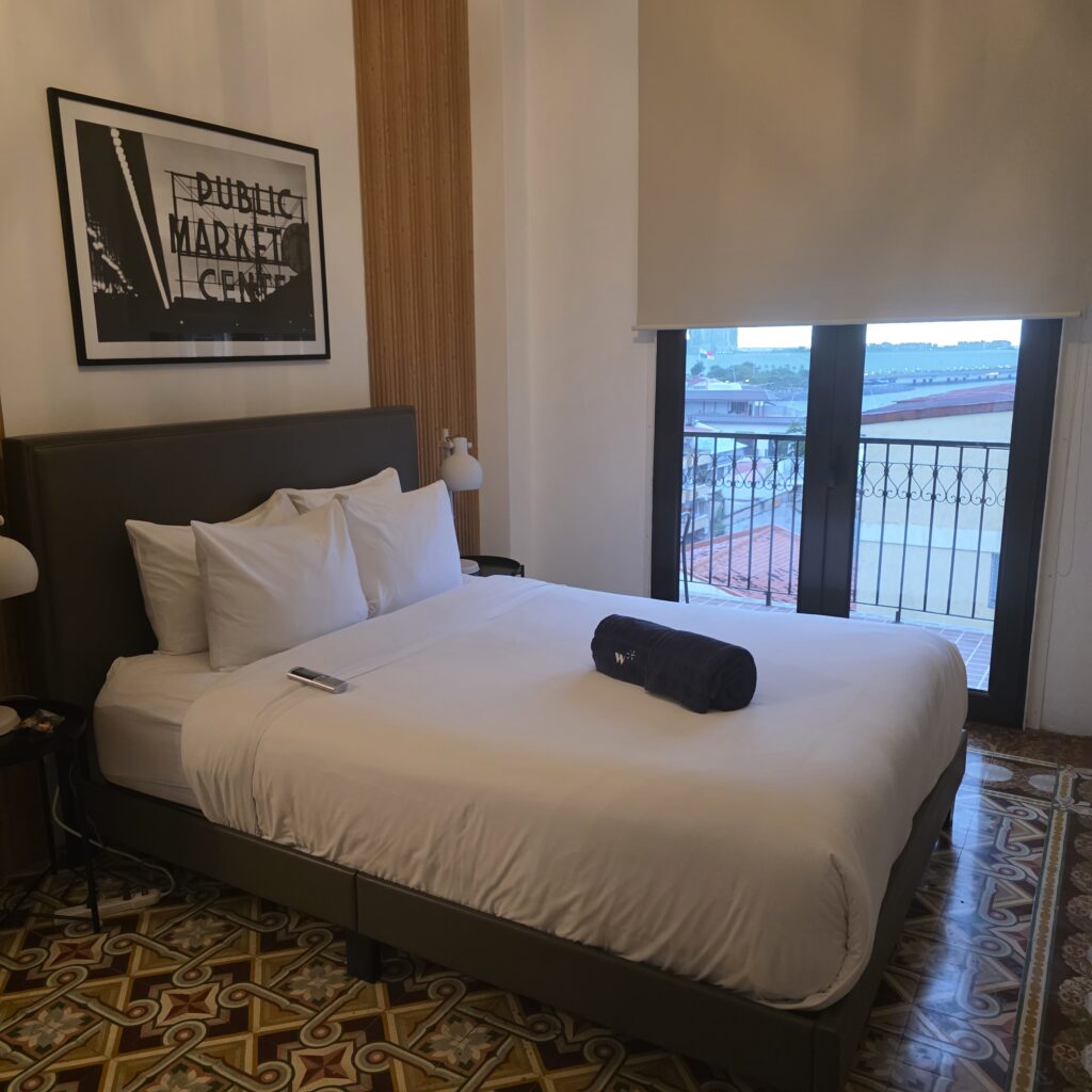Bed and view of the window out to the balcony in Donovan Hotel in Casco Viejo Panama