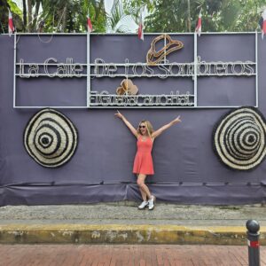 Me in a organge short set posing in fron of the sign for Sombrero Street in Casco Viejo Panam