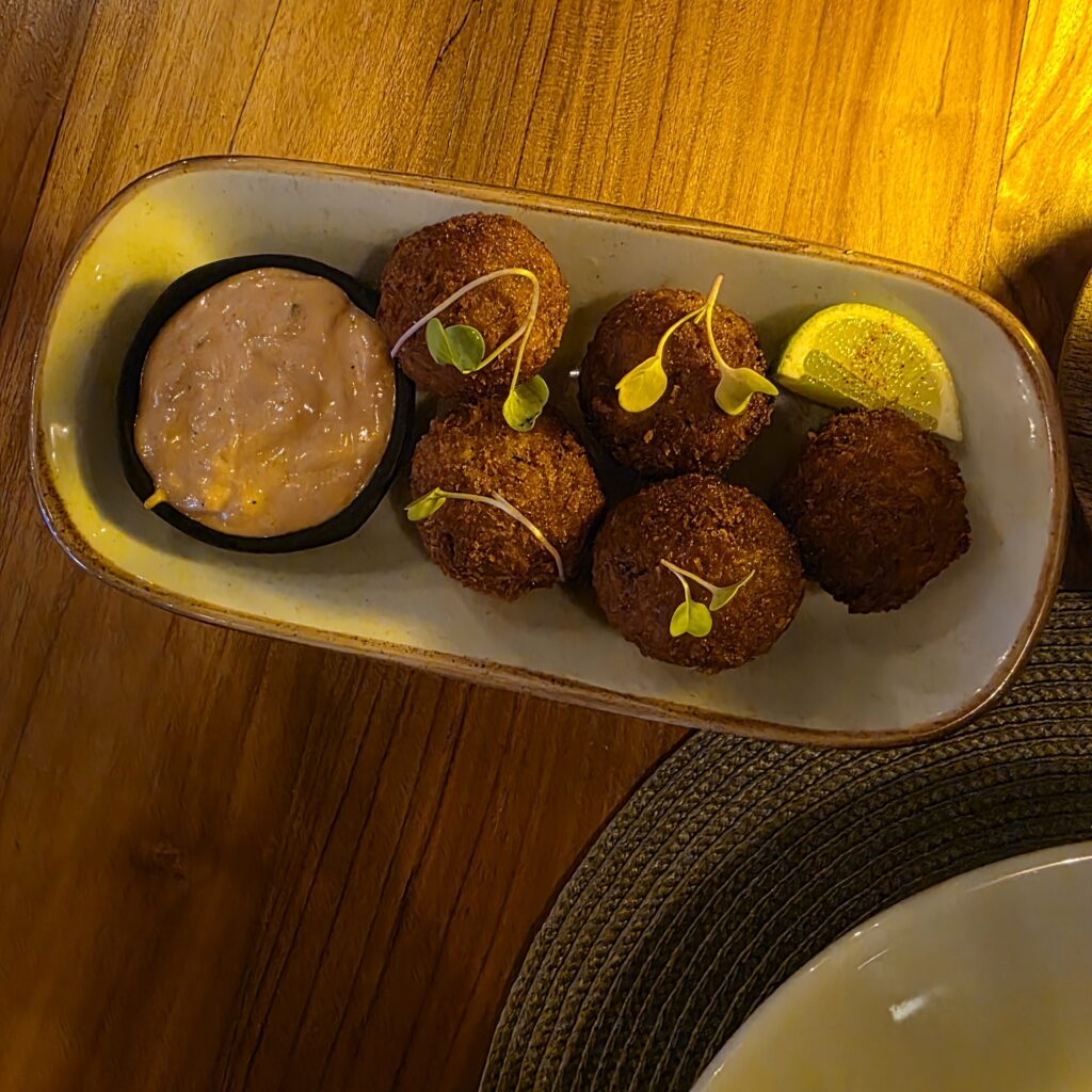 Food dish risotto balls with a dipping sauce.